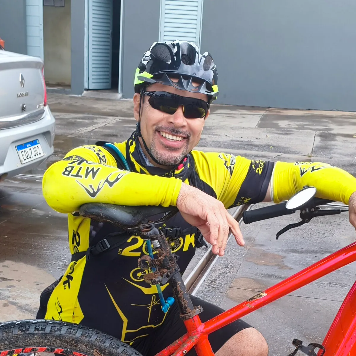 Armando, fundador do Grupo 200K, sorrindo de capacete e camisa do grupo